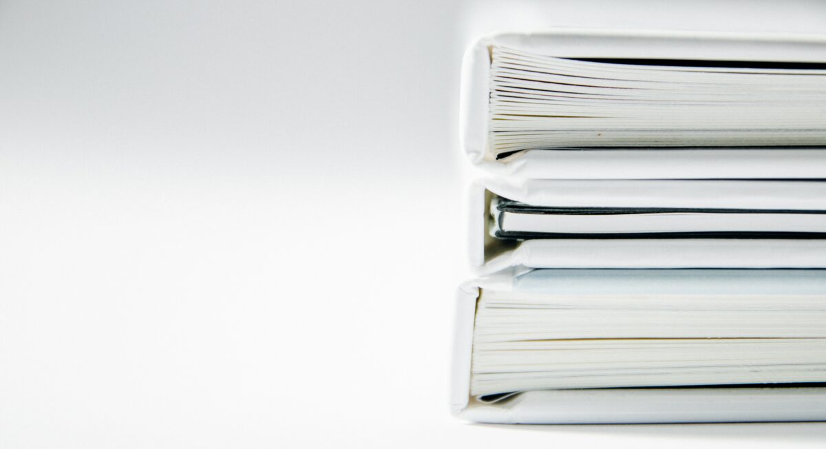 Leverage strategy for intellectual property: white background, three white binders stacked on top of one another