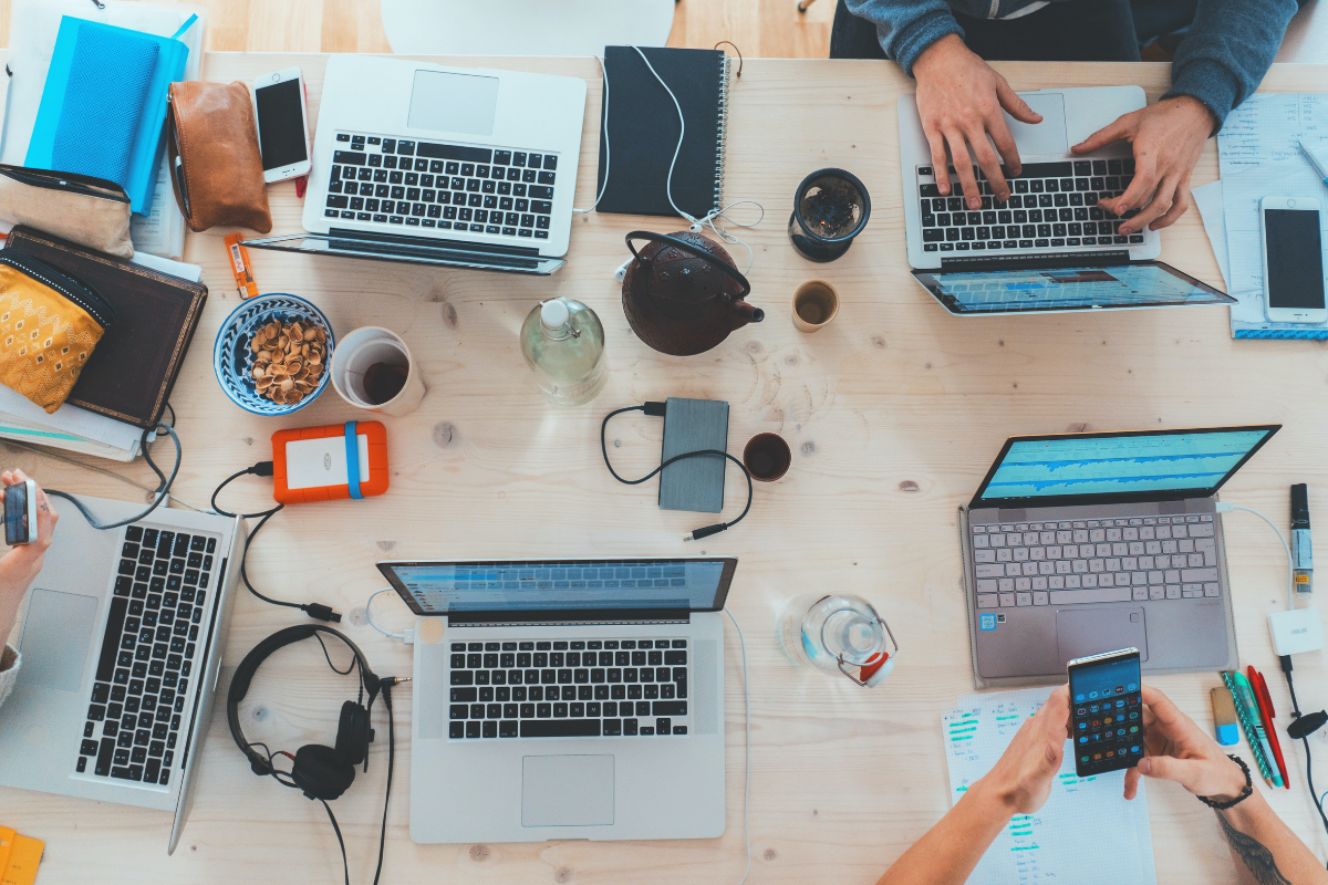 E-learning sector: a table top with laptops and people working