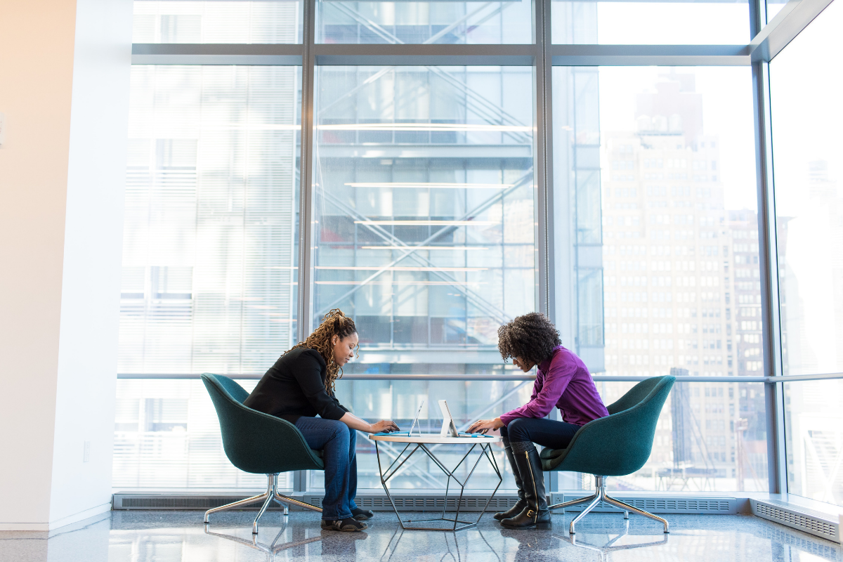 emotional intelligence: two business women sitting face to face in chairs, talking